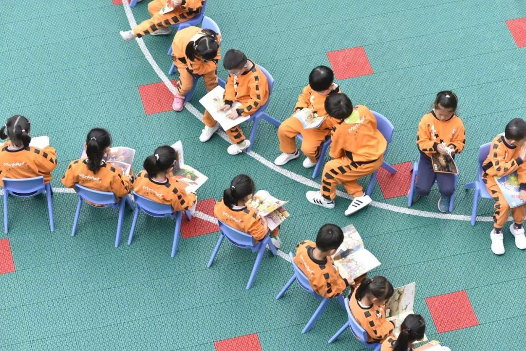 △在安徽合肥，幼儿园的孩子们坐在一起阅读图书。（图/视觉中国）